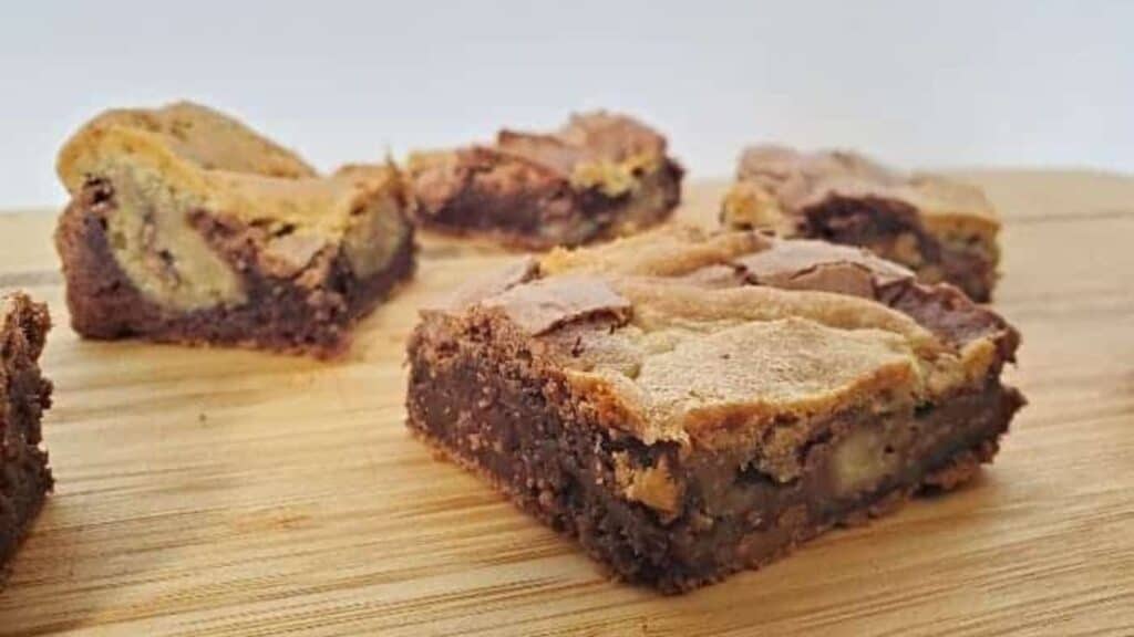 Image shows a close up of Candy Cookie Brownies on a wooden board.
