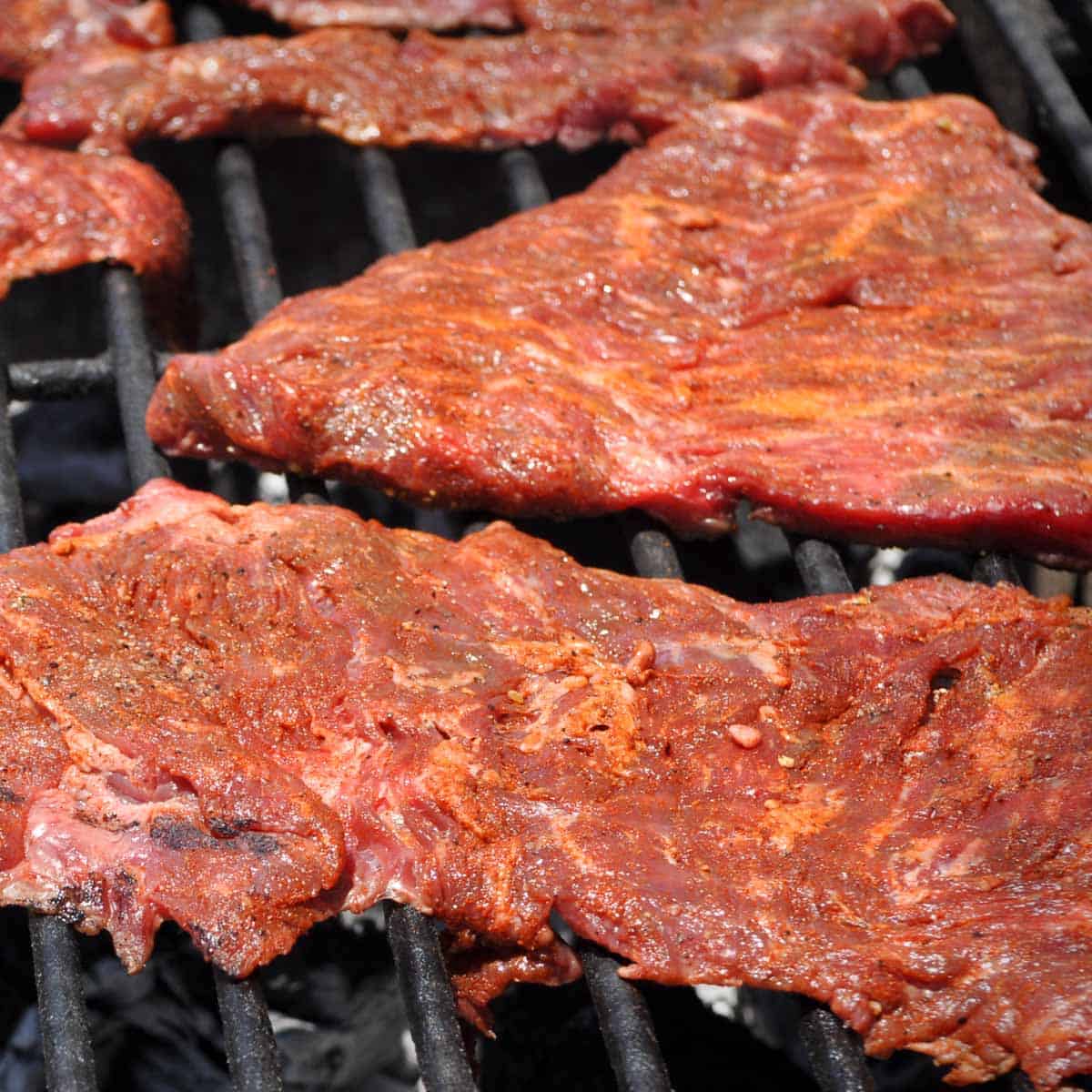 Carne asada cooking on a grill.