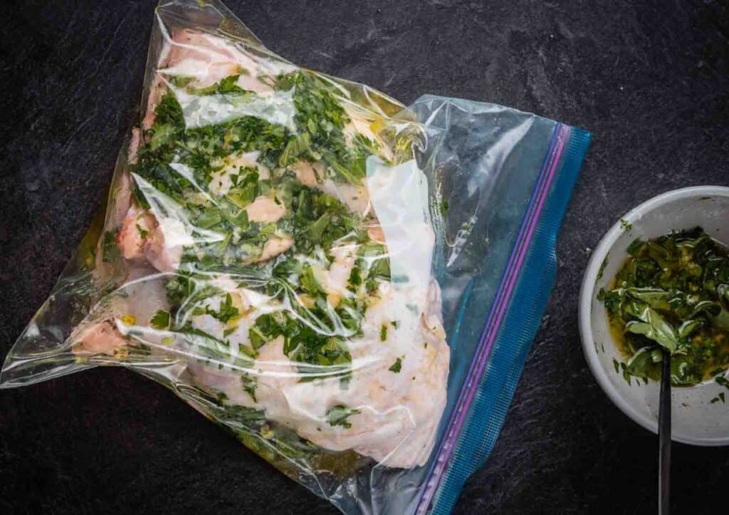 Resealable bag with chicken, herbs and marinade.