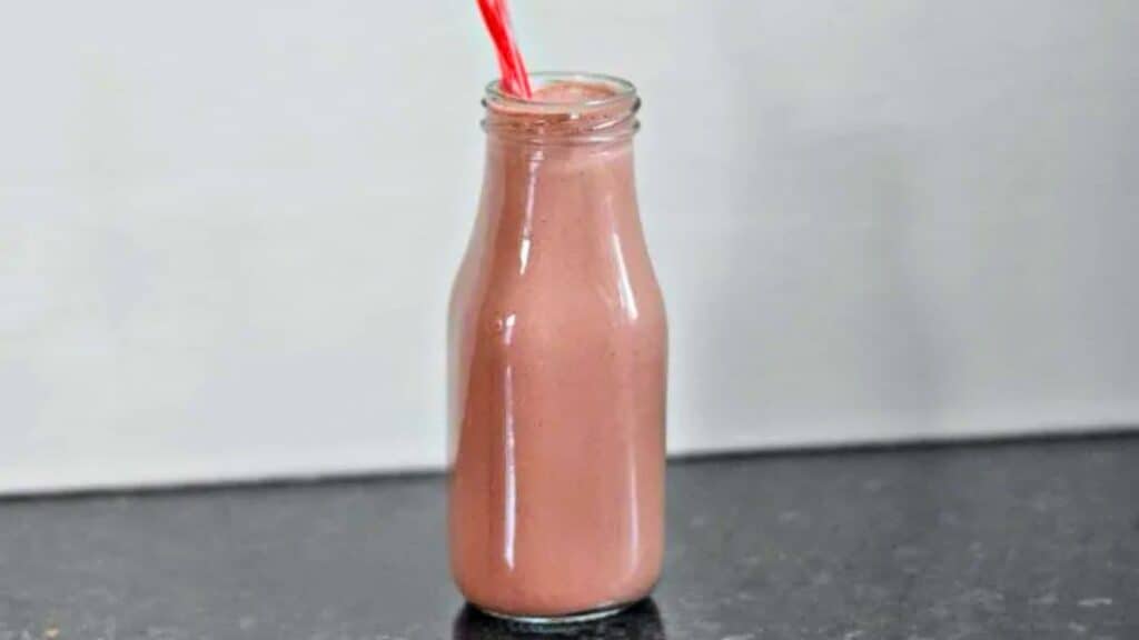 Image shows a Chocolate Cherry Smoothie in a milk bottle with a straw sticking out of it.