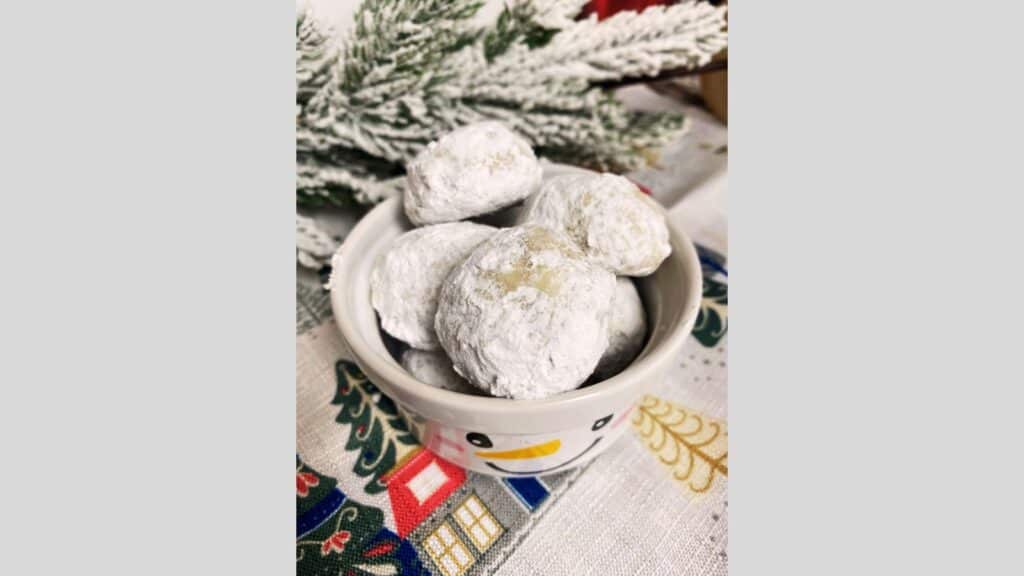 Christmas snowball cookies in white snowman dish.