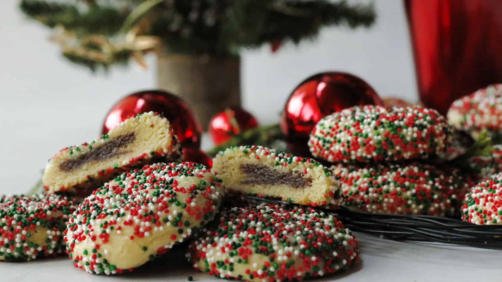 Cookies with red, green and white sprinkles with red Christmas balls.