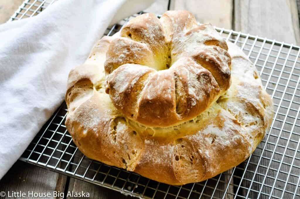 A double decker cottage loaf of bread on a wire cooling rack. 