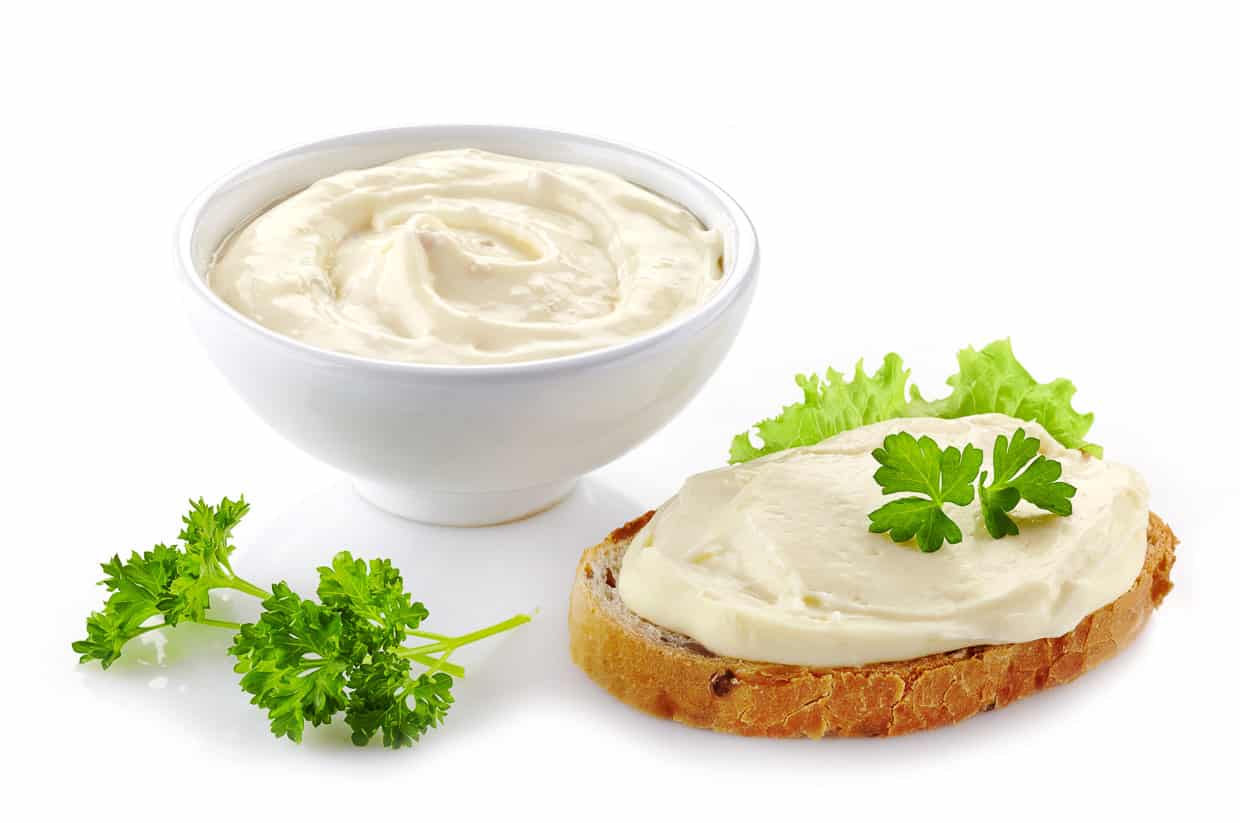 Bread with cream cheese on white background.