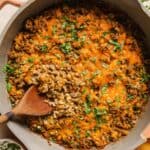 Creamy ground beef skillet with cauliflower rice with a wooden spoon.