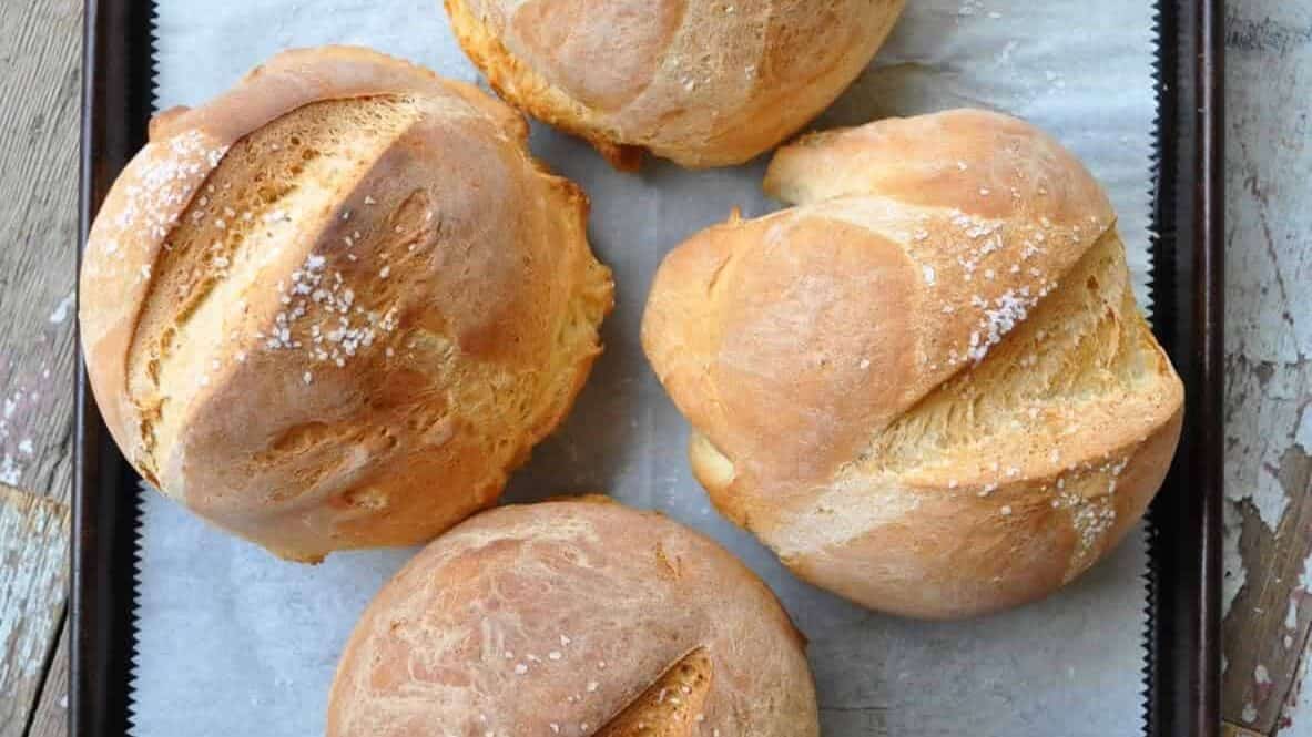 Bread bowls on a baking sheet with parchment paper.