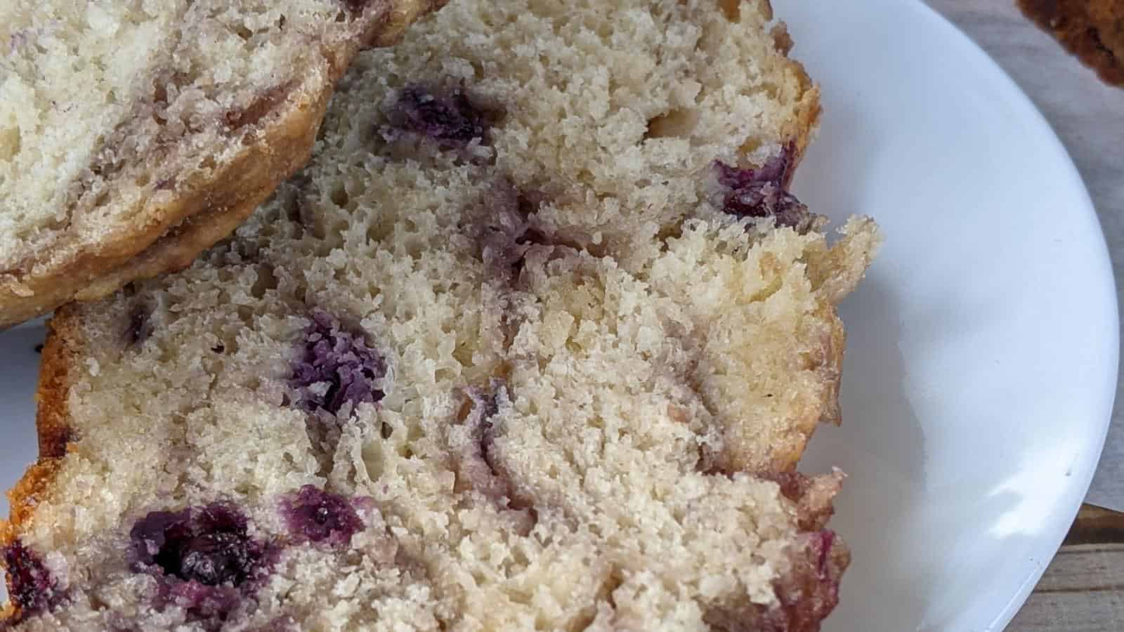 Two pieces of dutch oven blueberry bread on a plate.