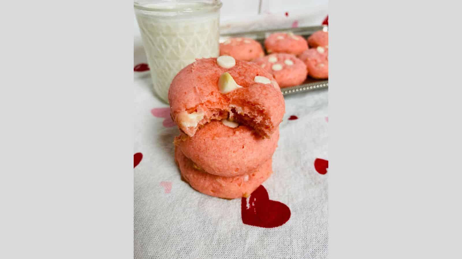 A stack of pink cookies with a bite taken out of them.