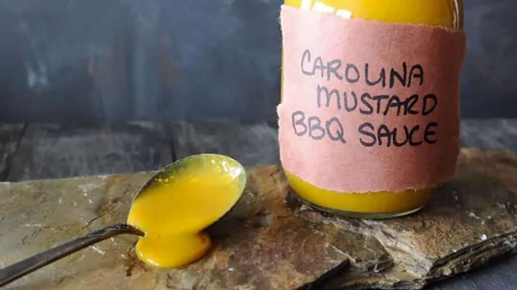 Jar of Carolina Mustard BBQ sauce next to spoon.