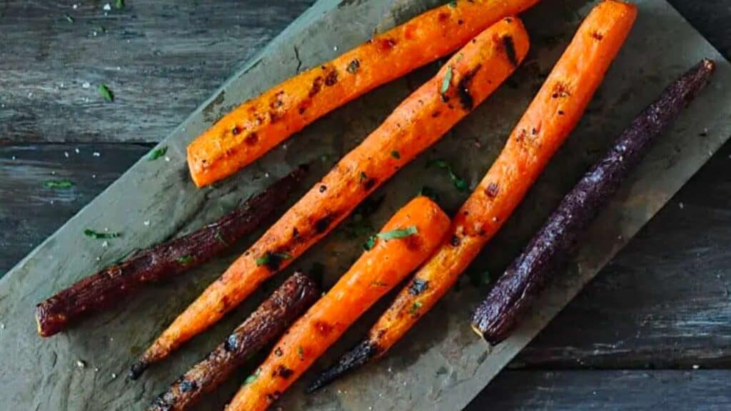 Platter of grilled orange and purple carrots.