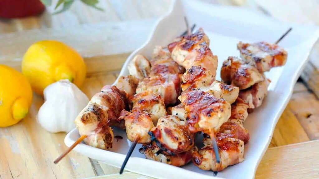Skewers of chicken wrapped with pancetta.