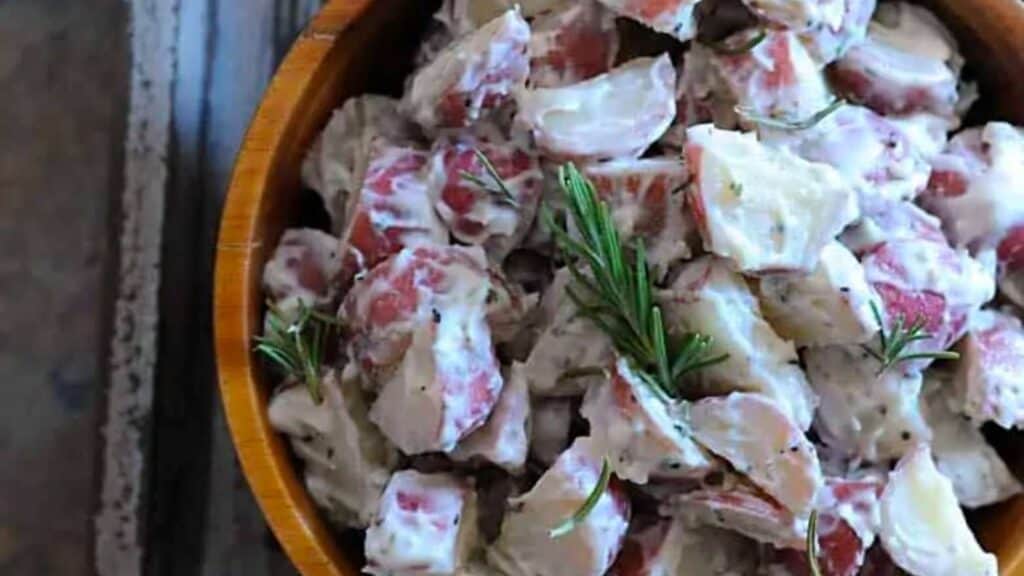 Sous vide potato salad in bowl with fresh herbs.