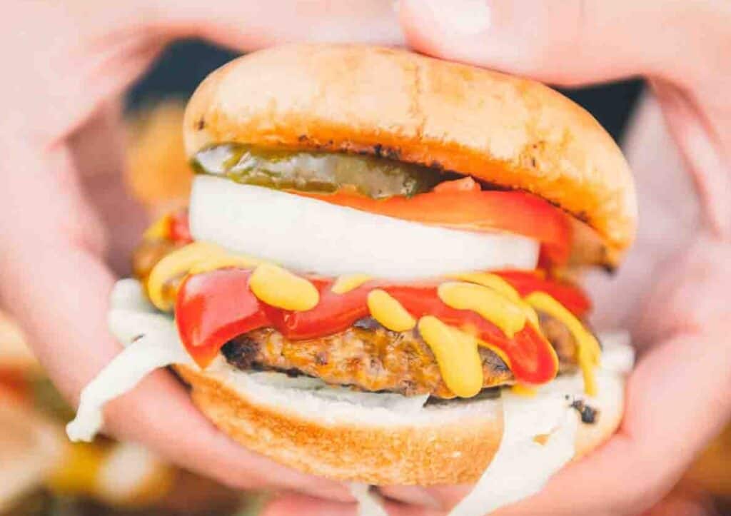 Hands holding burger.