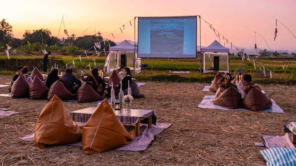 Families at an oudoor movie night in a field.