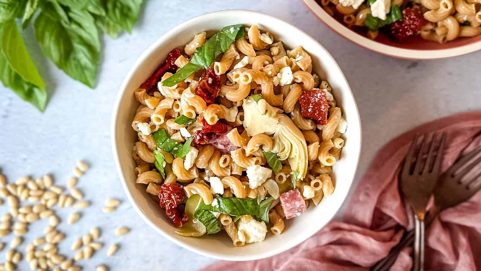 Whole wheat pasta salad in a white bowl.