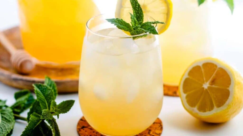 A glass of Iced Green Tea garnished with fresh mint.