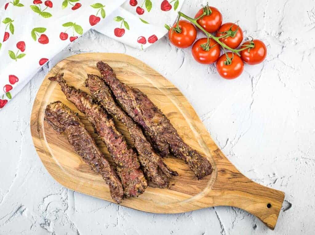 Grilled Beef Finger Meat on a wooden cutting board.