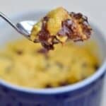 Image shows a close up of a spoon holding a bite of an Individual Chocolate Chip Cookie with the full cookie in the ramekin behind it.