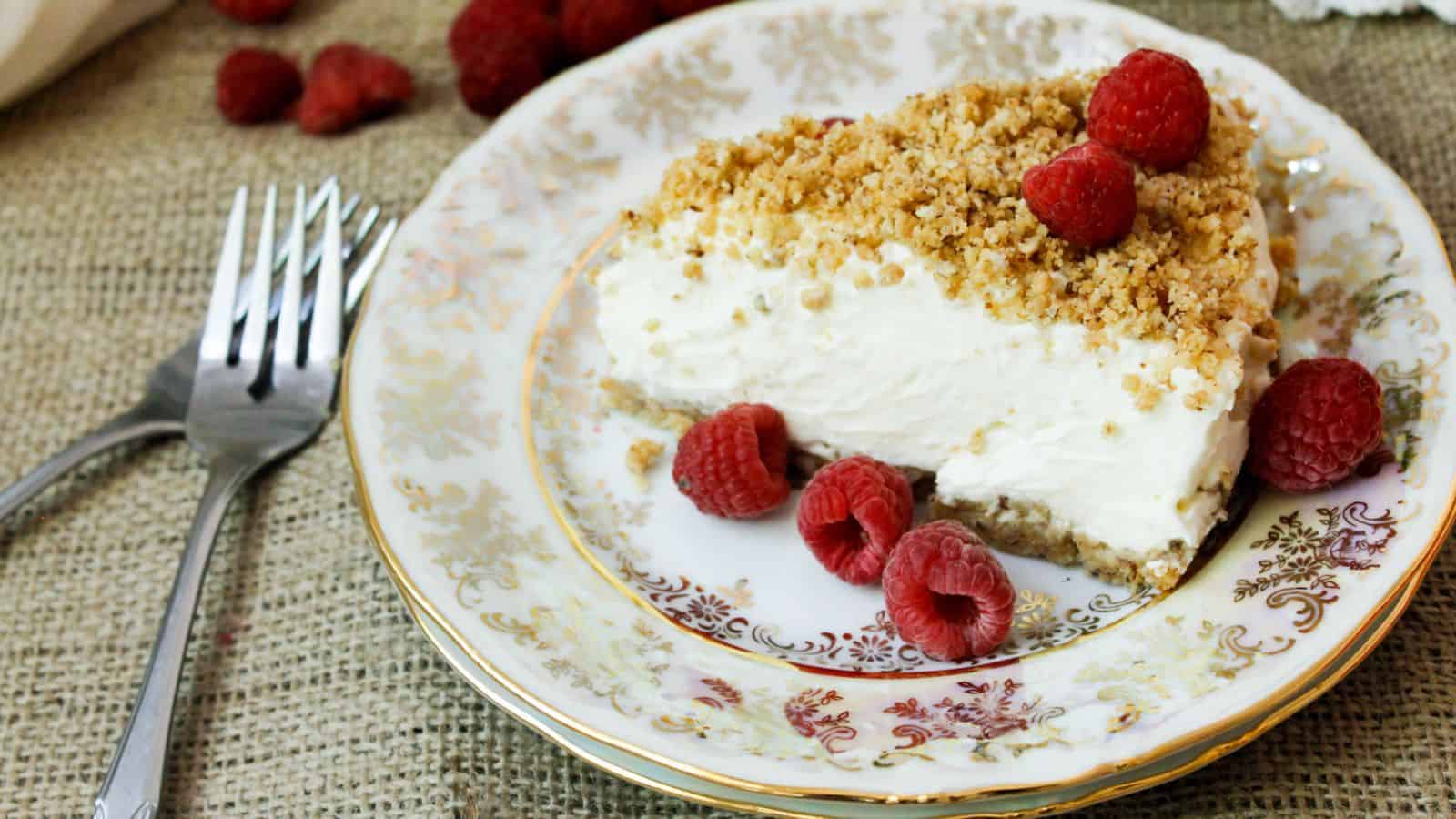 Side view of cheesecake slice with raspberries.