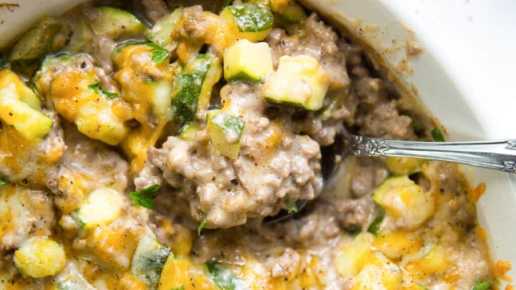 Keto zucchini minced beef casserole in a bowl with a spoon.