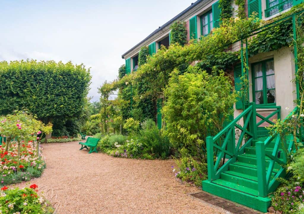A lush, manicured garden surrounding the adobe farmhouse of famed painter Claude Monet.