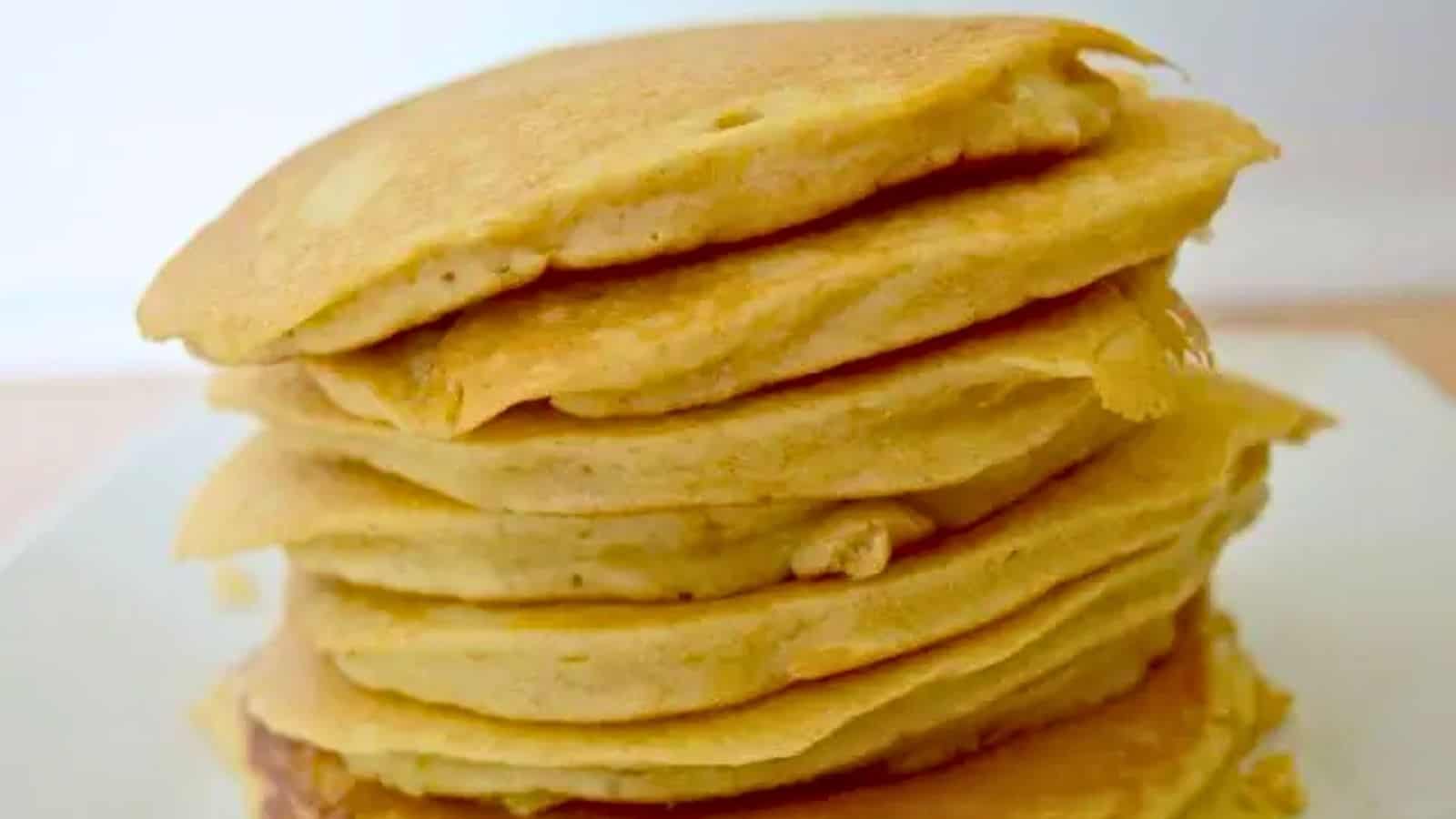Image shows a close up of a stack of Oatmeal Pancakes on a white plate.