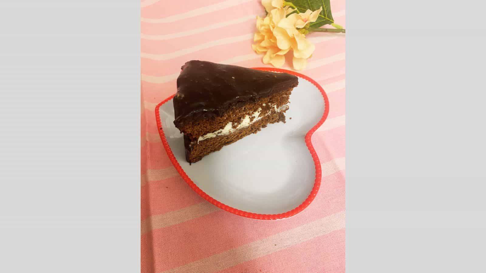 Slice of chocolate cake on heart-shaped plate.