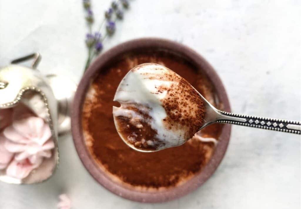 A spoonful of overnight oats tiramisu over a pretty bowl.