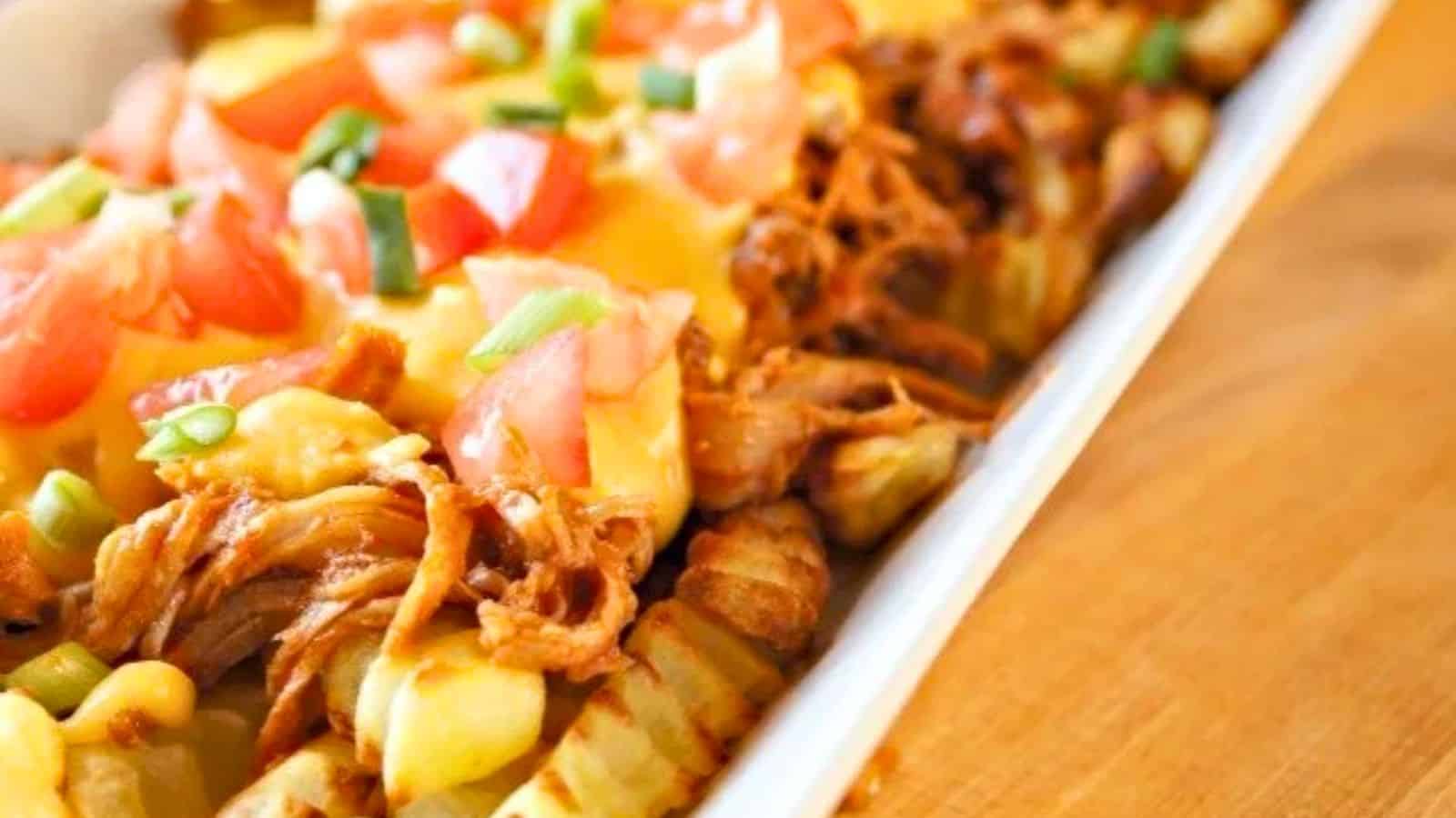 Image shows a white tray filled with Pulled Pork French Fry Nachos.