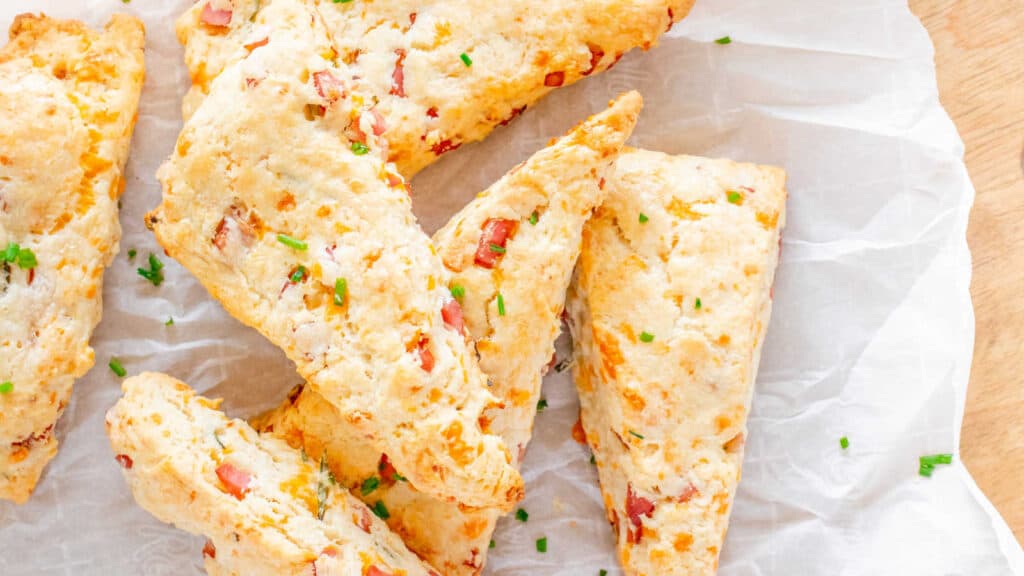 Ham and cheese scones on parchment paper.