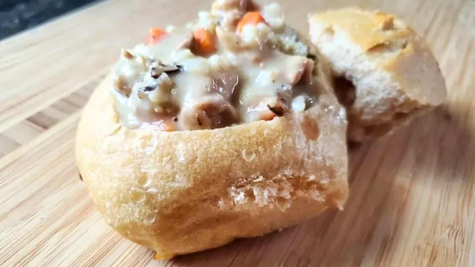 Image shows a closeup of a Sourdough Bread Bowl filled with chicken and wild rice soup.