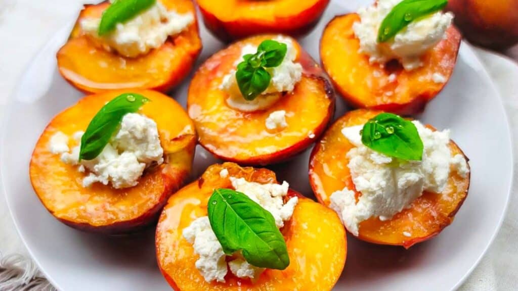 Stuffed peaches on a platter topped with mint.