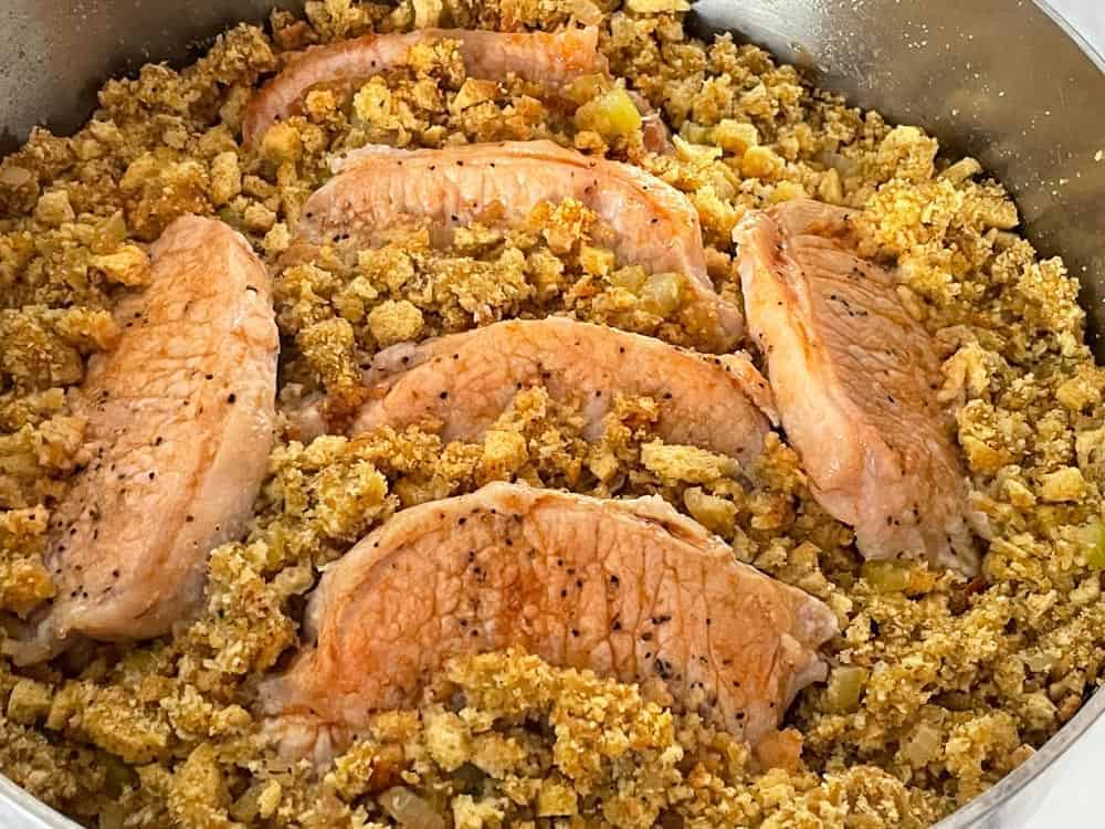 Stuffing and pork chops in a frying pan.