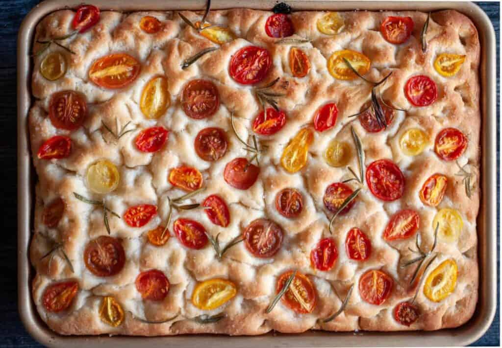 Baked focaccia with sliced tomatoes and rosemary.