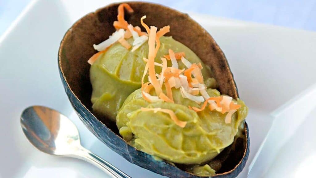 Avocado shell filled with two scoops of avocado ice cream topped with toasted coconut.