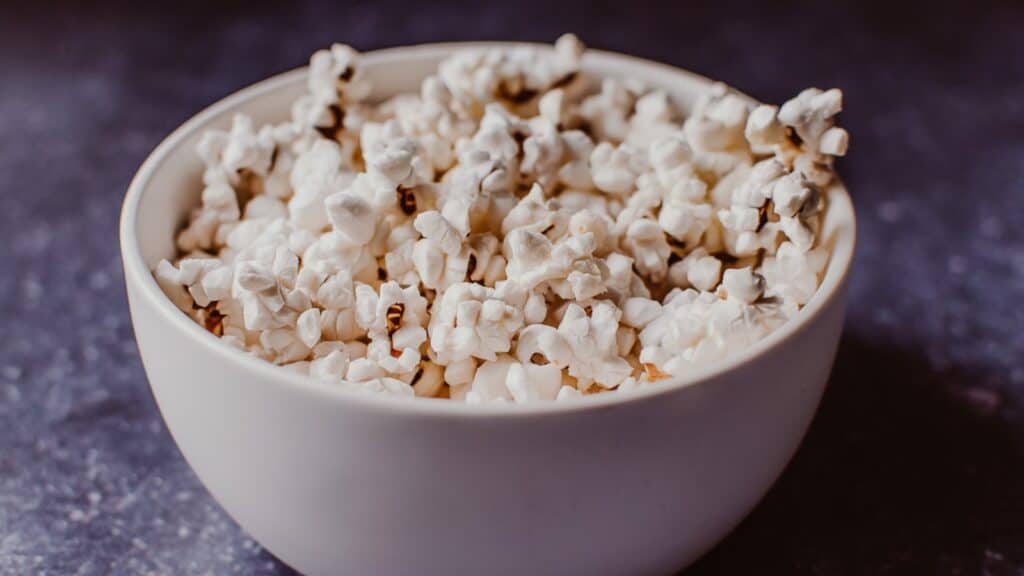 A small white ceramic bowl filled with white popcorn.