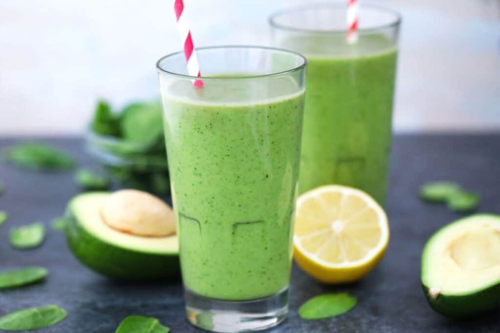 Two tall glasses of avocado spinach smoothie.