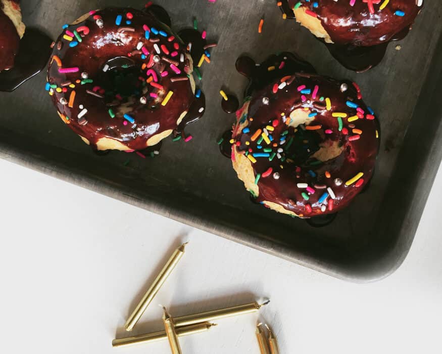 Donuts on a tray with chocolate icing and sprinkles