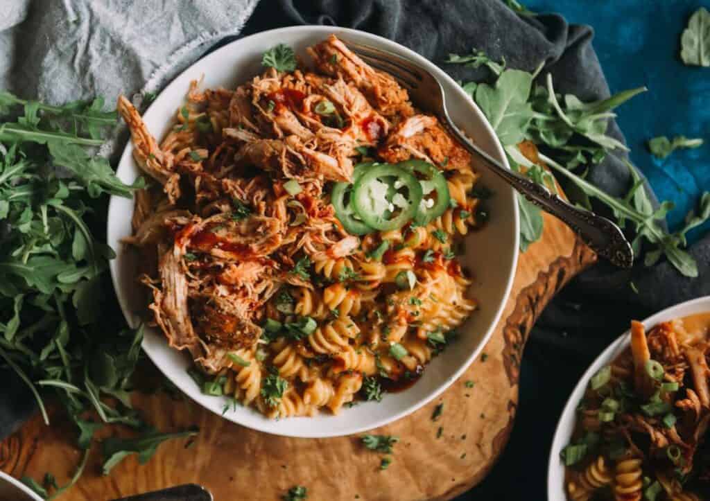 Bowl filled with shredded chicken over pasta.