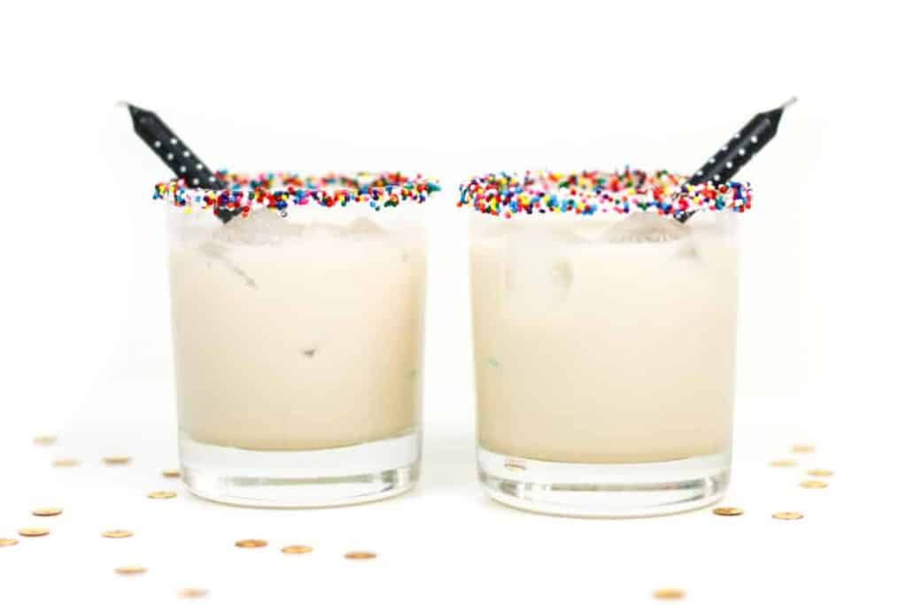 A birthday cake cocktail with a sprinkle rim.