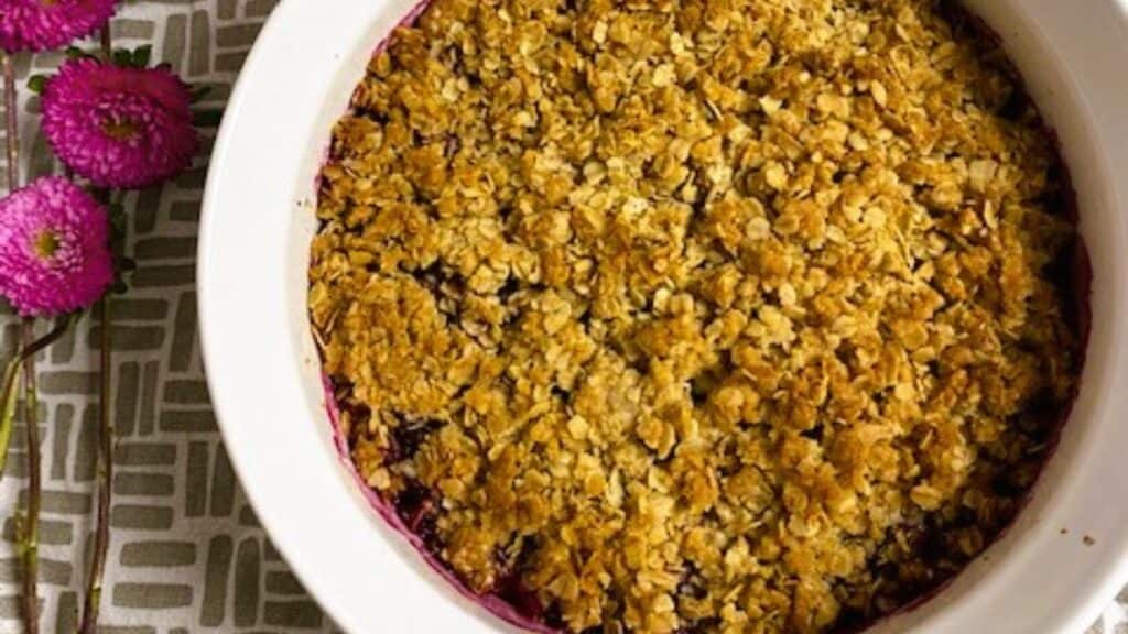 A white baking dish filled with a blueberry crisp dessert.