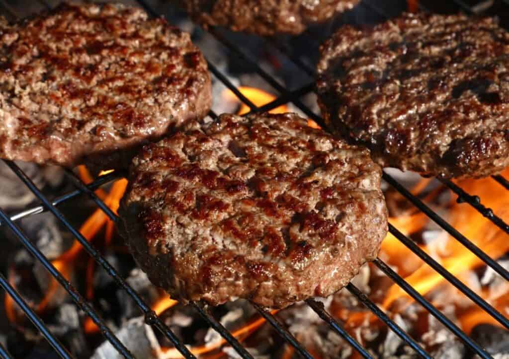 Burgers on the grill grates. 