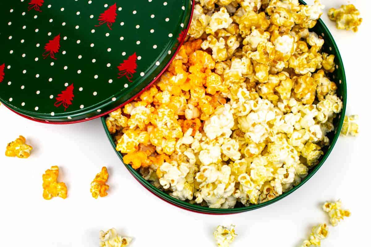 A top view of a DIY popcorn tin with a trio of three flavors of Christmas popcorn.