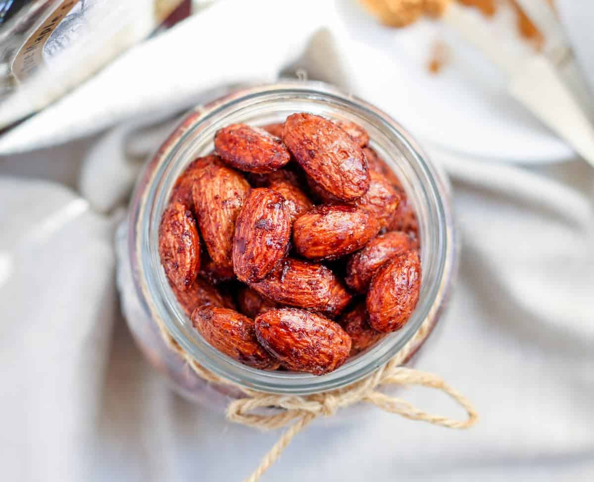 An overhead image of cinnamon roasted almonds in a jar.