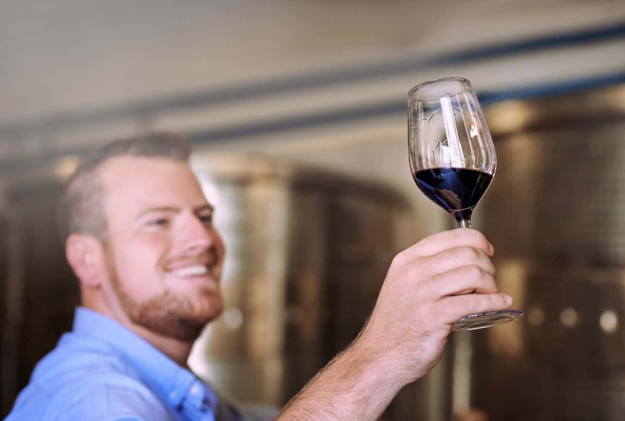 Man holding glass of red wine.