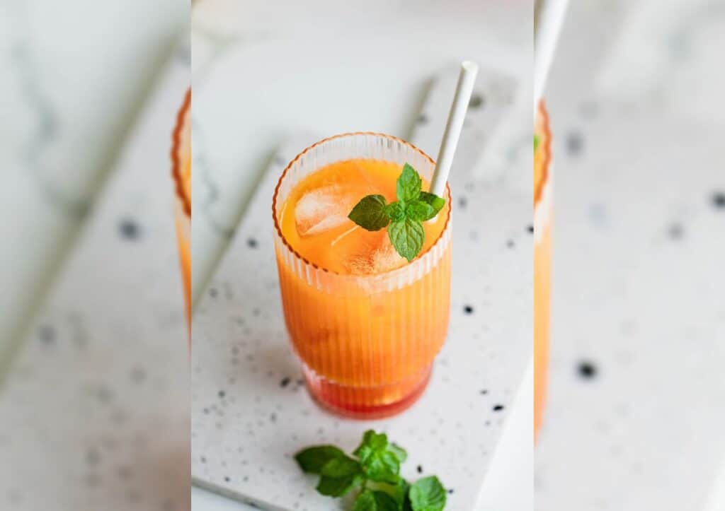 Orange drink in glass with mint.