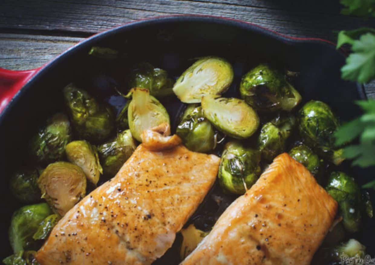 Overhead shot of baked salmon over brussels sprouts. 