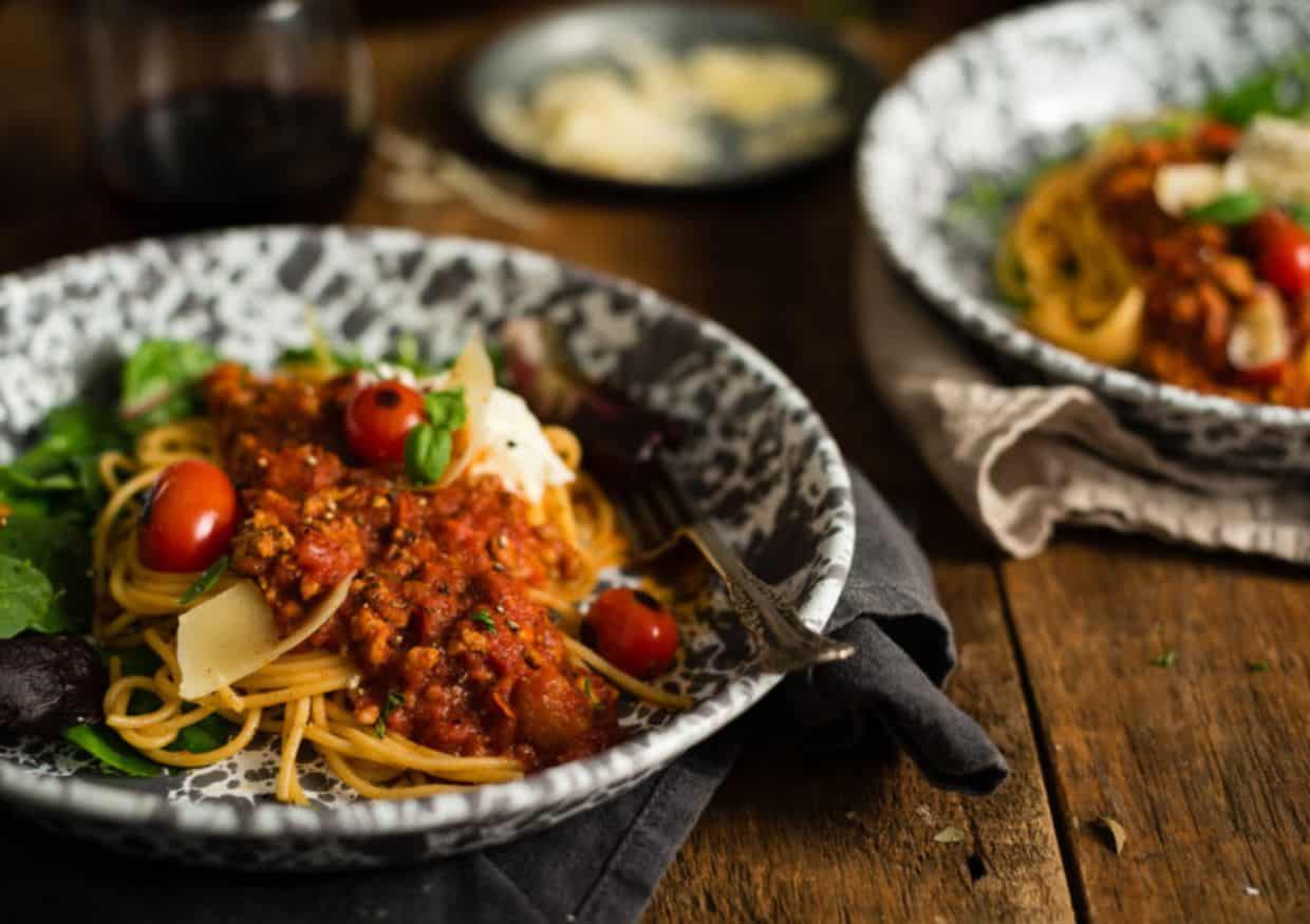 Platters of pasta topped with meat sauce. 