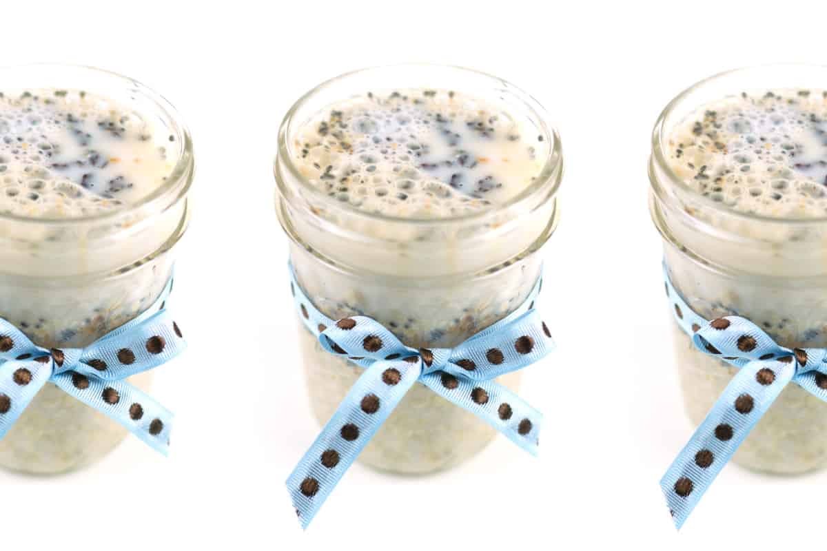 Three jars of peanut butter overnight oats decorated with ribbons on a white background.