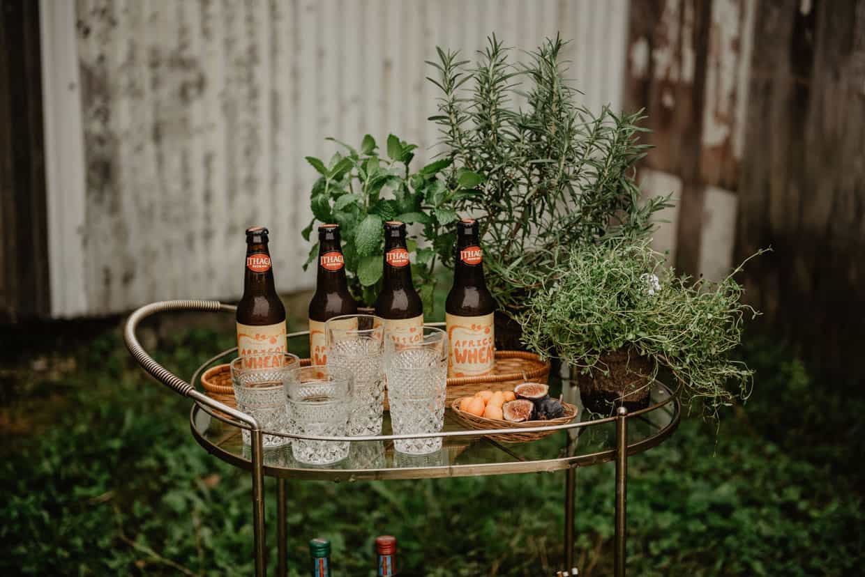 An outdoor bar cart stocked with beer and glassware. 
